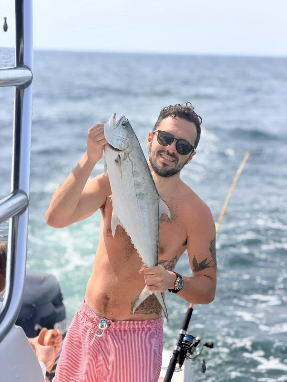 Guest holding up a large kingfish from the boat